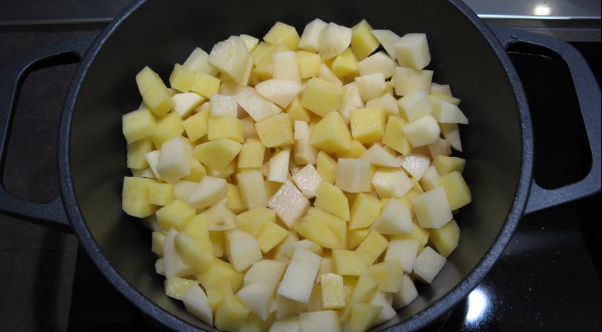 Нарезать картофель и добавить к овощам в казане
