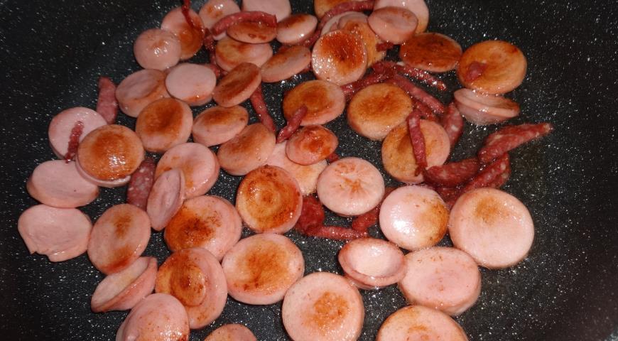 Нарезаем и обжариваем сосиски и колбасу для солянки из капусты