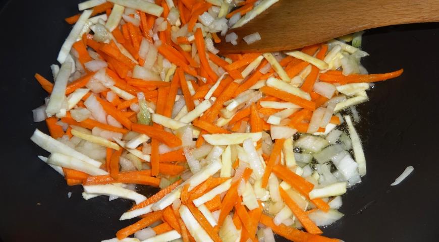 Нарезаем и обжариваем лук, морковь и пастернак для солянки с беконом