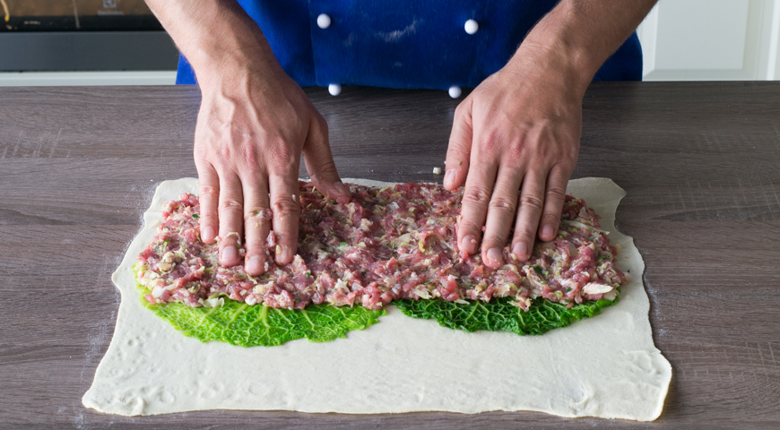 Штрудель с мясом, на пласт теста уложите листья савойской капусты и распределите начинку